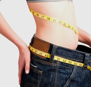 A person measuring their waist fat after inch loss treatment. 
